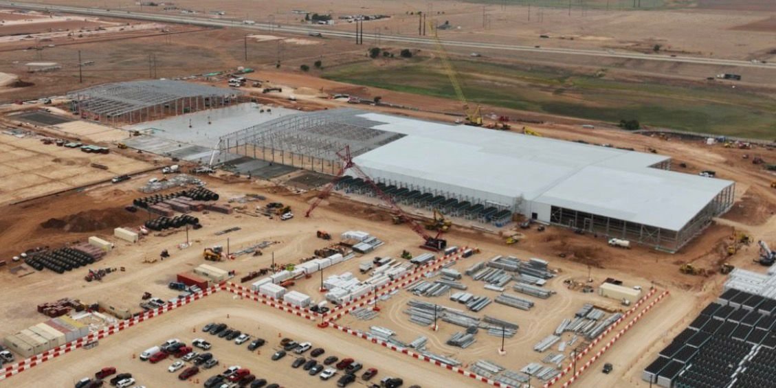 Aerial view of a data center under construction — steel structure, concrete slabs and laydown yard